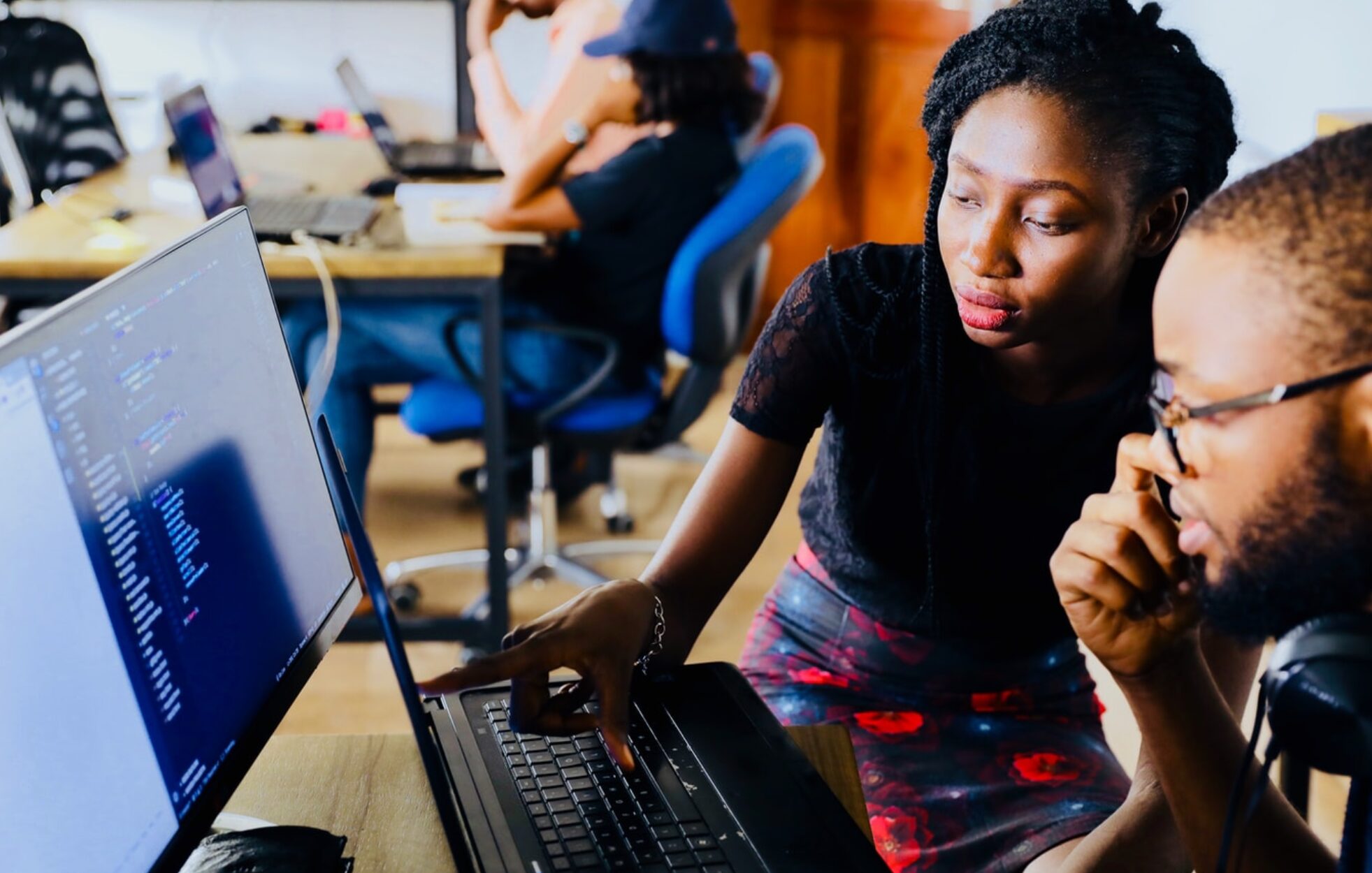 woman and man sitting in front of monitor